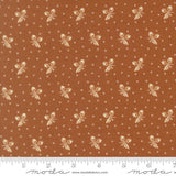 The image is a fabric with a repeating pattern of brown and white acorns or leaves, creating a visually appealing and textured design.