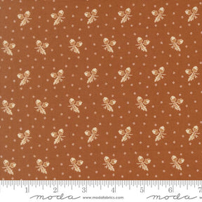 The image is a fabric with a repeating pattern of brown and white acorns or leaves, creating a visually appealing and textured design.
