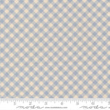 a fabric with a blue and beige checkered pattern. The fabric appears to be a light blue color, and the pattern consists of small squares or rectangles arranged in a diagonal grid-like pattern. The fabric is laid out flat, and there is a ruler visible at the bottom of the image.
