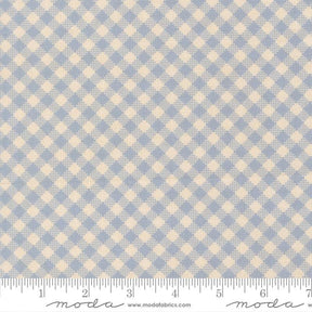 a fabric with a blue and beige checkered pattern. The fabric appears to be a light blue color, and the pattern consists of small squares or rectangles arranged in a diagonal grid-like pattern. The fabric is laid out flat, and there is a ruler visible at the bottom of the image.