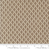 a repeating pattern of brown and beige flowers or leaves on a fabric surface.