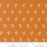 The image is a fabric with a repeating pattern of small white acorns or leaves against an orange background. The pattern is evenly spaced and creates a visually appealing design.