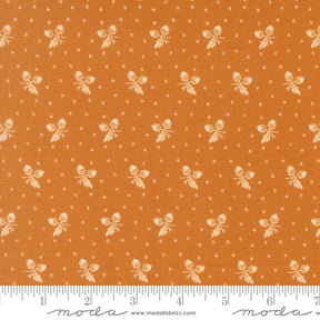The image is a fabric with a repeating pattern of small white acorns or leaves against an orange background. The pattern is evenly spaced and creates a visually appealing design.