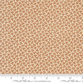 The image is a fabric with a repeating pattern of brown leaves or flowers on a cream-colored background.