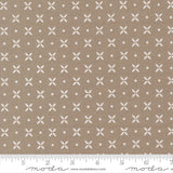 The image is a fabric with a repeating pattern of white crosses and dots on a beige background.