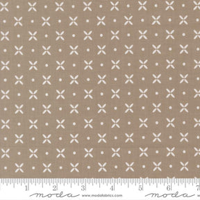 The image is a fabric with a repeating pattern of white crosses and dots on a beige background.