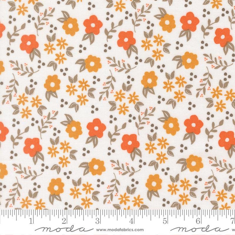 The image is a fabric with a repeating pattern of orange and yellow flowers and leaves on a white background.