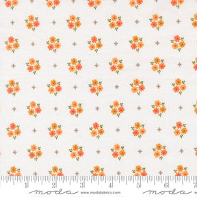 a repeating pattern of small orange flowers on a white background, with a ruler for scale at the bottom.