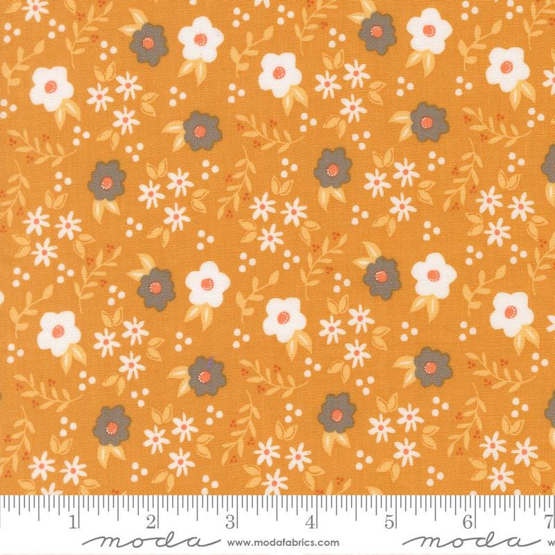 The image is a fabric with a repeating pattern of white and orange flowers and leaves on a yellow background.