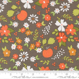 The image is a fabric with a floral pattern featuring various flowers and pumpkins in shades of orange, white, and green.
