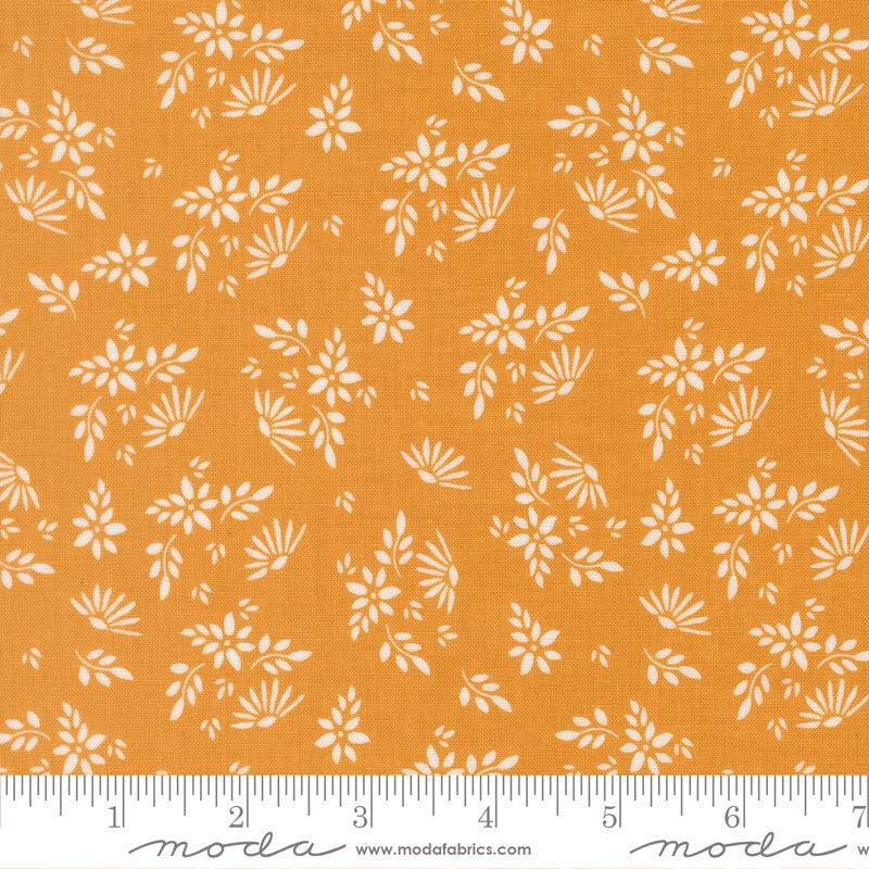 a fabric with a repeating pattern of white flowers and leaves on an orange background. The pattern is spread across the fabric, creating a visually appealing design.