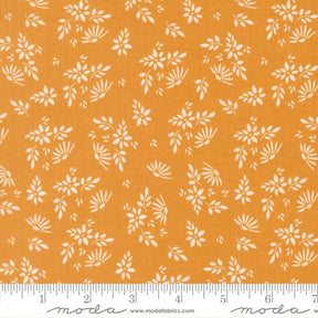 a fabric with a repeating pattern of white flowers and leaves on an orange background. The pattern is spread across the fabric, creating a visually appealing design.