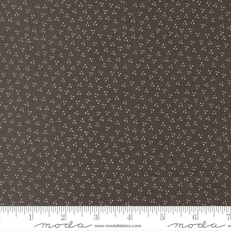 a close-up view of a fabric with a dark brown color and small white dots or specks covering the entire surface.