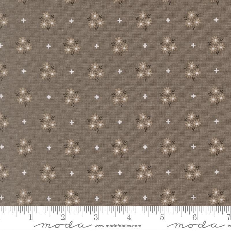 The image is a fabric with a repeating pattern of brown flowers and white stars. The pattern is evenly spaced across the fabric, creating a visually appealing design.