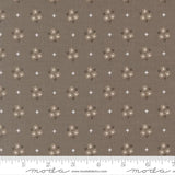 The image is a fabric with a repeating pattern of brown flowers and white stars. The pattern is evenly spaced across the fabric, creating a visually appealing design.