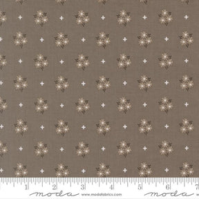 The image is a fabric with a repeating pattern of brown flowers and white stars. The pattern is evenly spaced across the fabric, creating a visually appealing design.