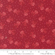 a red fabric with a repeating pattern of red roses and white dots.