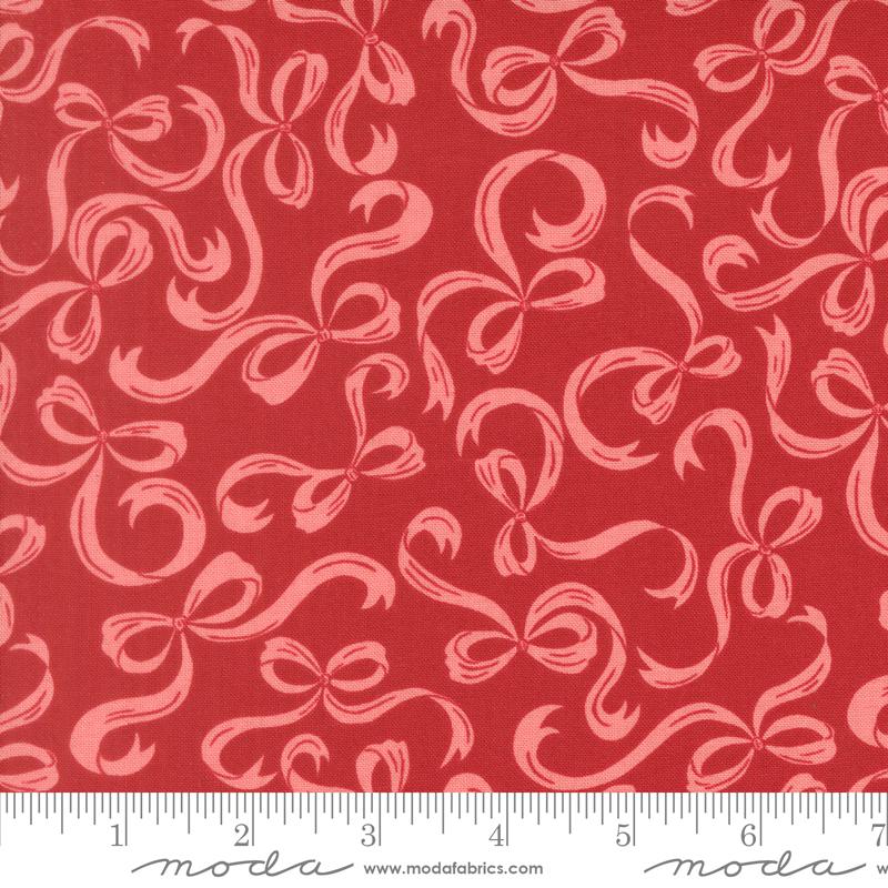 a red fabric with a repeating pattern of pink bows on it.