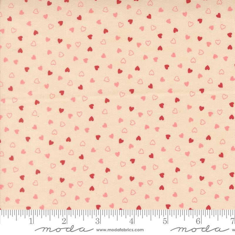 The image is a fabric with a repeating pattern of small hearts in shades of pink and red. The pattern is spread across the fabric, creating a visually appealing and textured design.