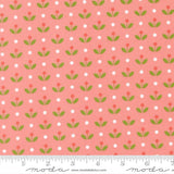 a repeating pattern of green leaves and red flowers on a pink background, with white polka dots scattered throughout.