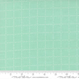 The image is a fabric with a grid pattern of small white dots or stars, creating a mint green or light green color.