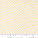 a fabric with diagonal yellow stripes arranged in a repeating pattern. The fabric is white and has a ruler placed at the bottom to indicate its size.