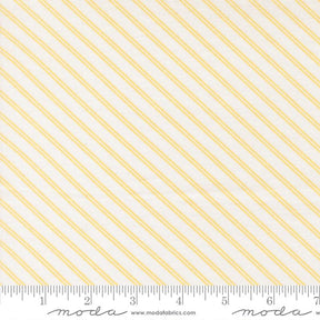 a fabric with diagonal yellow stripes arranged in a repeating pattern. The fabric is white and has a ruler placed at the bottom to indicate its size.