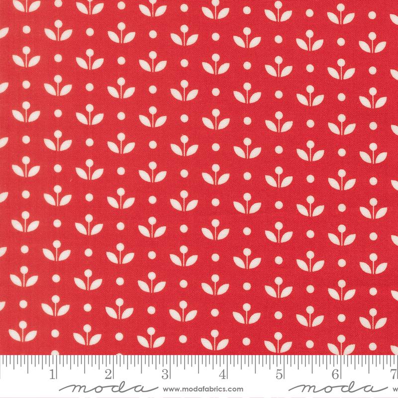 a red fabric with a repeating pattern of white flowers and dots. The pattern is evenly spaced and creates a visually appealing design.