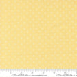 The image is a close-up of a fabric with a yellow background and white polka dots.
