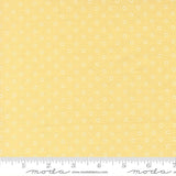 The image is a close-up of a fabric with a yellow background and white polka dots.