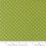 a close-up view of a fabric with a green background and white polka dots. The fabric appears to be a type of textile, possibly used for clothing or home decor.