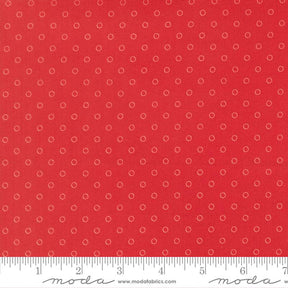 The image is a close-up of a red fabric with white polka dots, and there is a ruler for scale at the bottom of the image.
