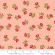 a fabric with a repeating pattern of red roses and green leaves against a light pink background.