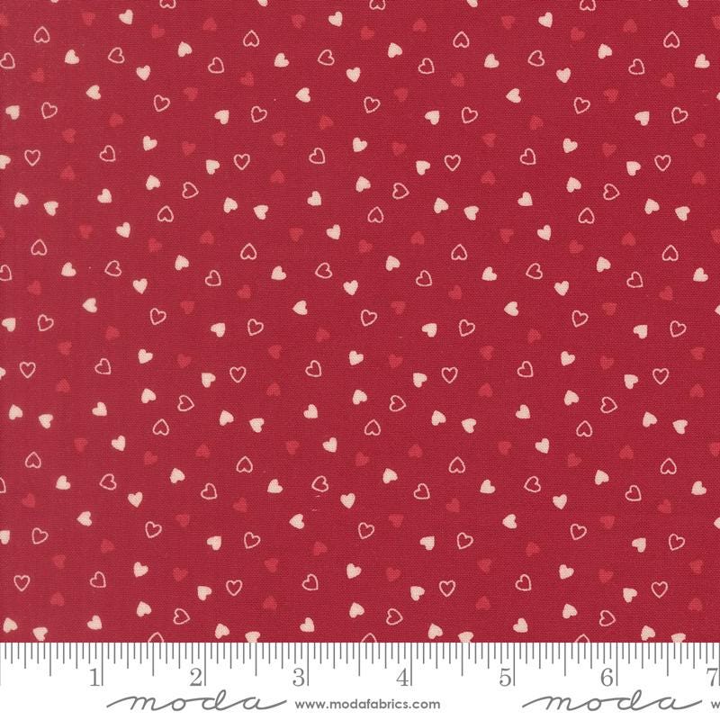 a red fabric with white hearts scattered across it.