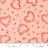 a fabric with a repeating pattern of pink hearts and flowers on a peach background.
