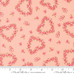 a fabric with a repeating pattern of pink hearts and flowers on a peach background.