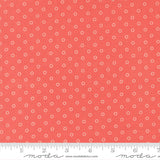a close-up view of a fabric with a repeating pattern of small white circles against a bright red background.