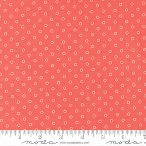 a close-up view of a fabric with a repeating pattern of small white circles against a bright red background.
