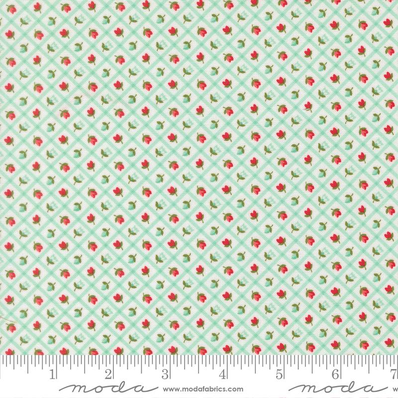 The image is a fabric with a repeating pattern of green and red flowers arranged in a diagonal grid. The pattern is composed of small red flowers interspersed with green flowers, creating a visually appealing and intricate design.