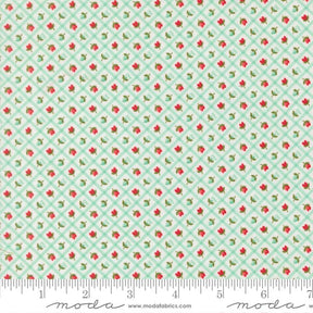 The image is a fabric with a repeating pattern of green and red flowers arranged in a diagonal grid. The pattern is composed of small red flowers interspersed with green flowers, creating a visually appealing and intricate design.
