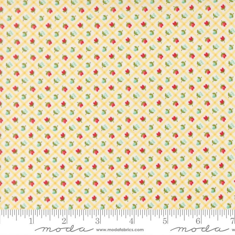 The image is a fabric with a yellow and green floral pattern, featuring small red and green flowers arranged in a diagonal grid.
