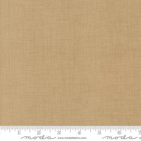 The image is a close-up of a fabric with a light brown or beige color. There is a ruler at the bottom of the image, indicating the size of the fabric in inches.