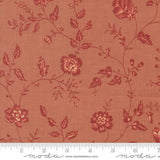 a fabric with a floral pattern in shades of red and orange. The pattern consists of various flowers and leaves, creating a visually appealing and intricate design. The fabric appears to be made of a soft, textured material, suitable for clothing or home decor.